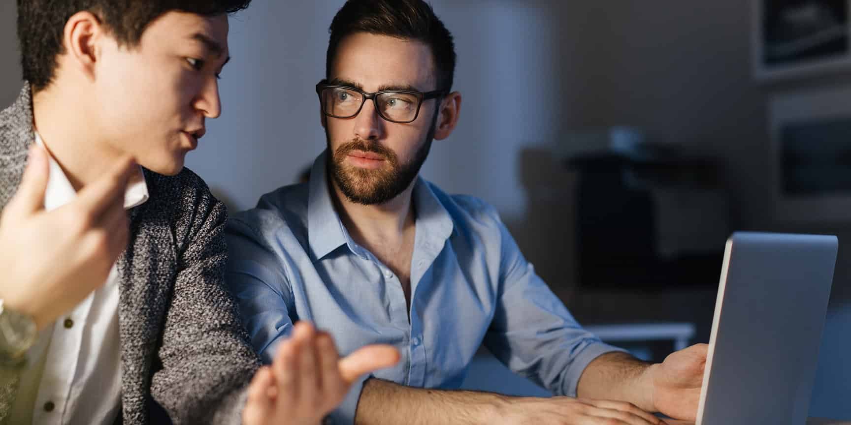 Young expert listening to his colleague while discussing new project